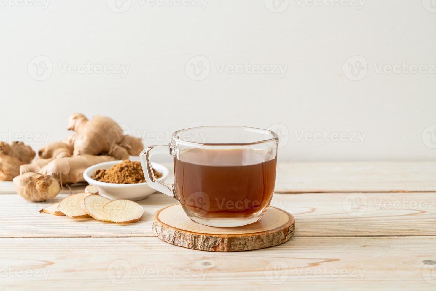 Hot and sweet ginger juice glass with ginger roots - Healthy drink style photo