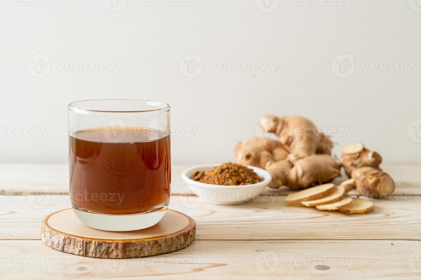 Hot and sweet ginger juice glass with ginger roots - Healthy drink style photo