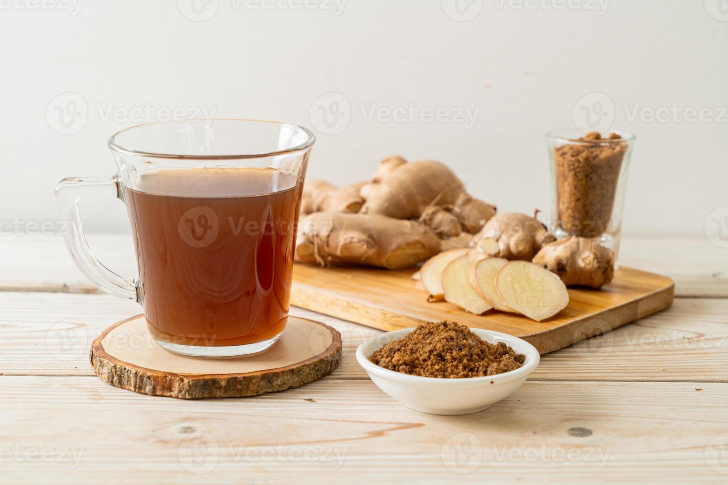 Vaso de jugo de jengibre caliente y dulce con raíces de jengibre - estilo de bebida saludable foto