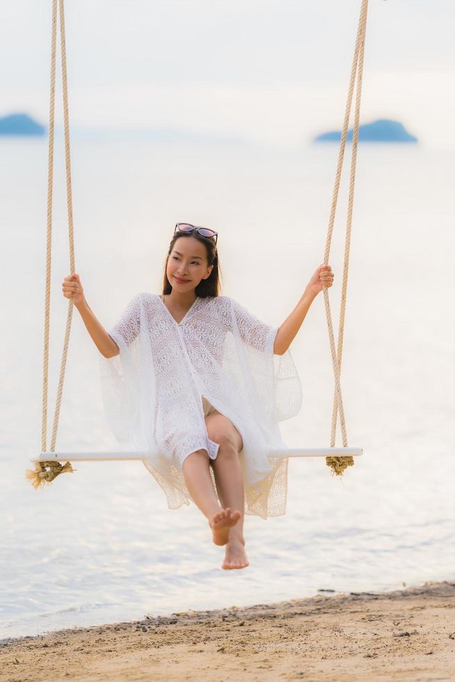 retrato, hermoso, joven, mujer asiática, sentado, en, el, columpio, alrededor, playa, mar, océano, para, relajarse foto