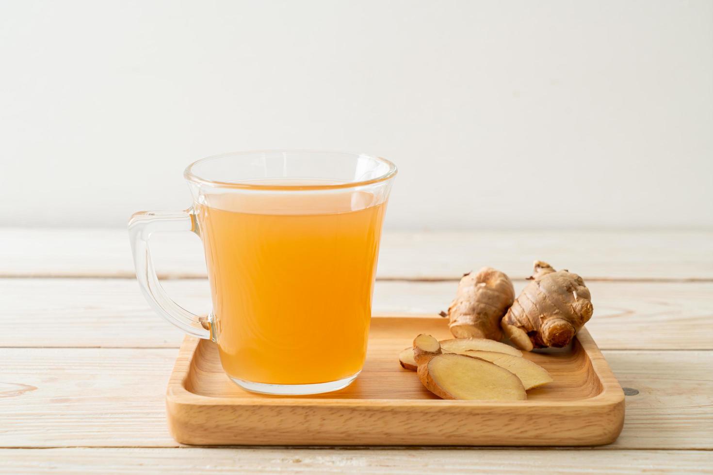 Fresh and hot ginger juice glass with ginger roots - Healthy drink style photo