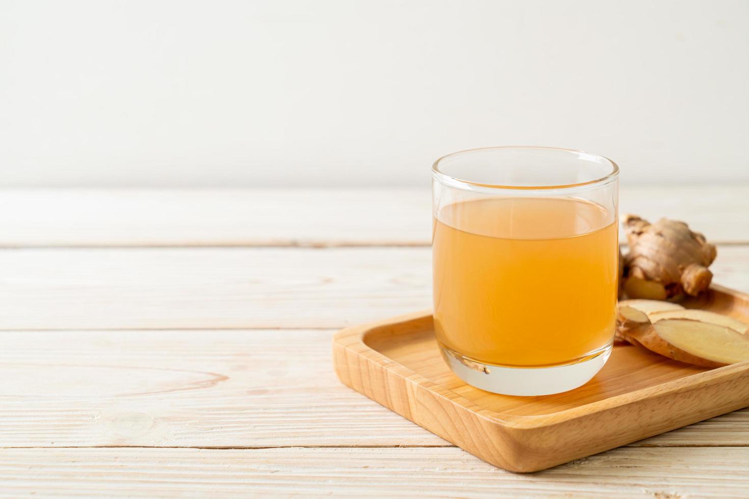 Fresh and hot ginger juice glass with ginger roots - Healthy drink style photo