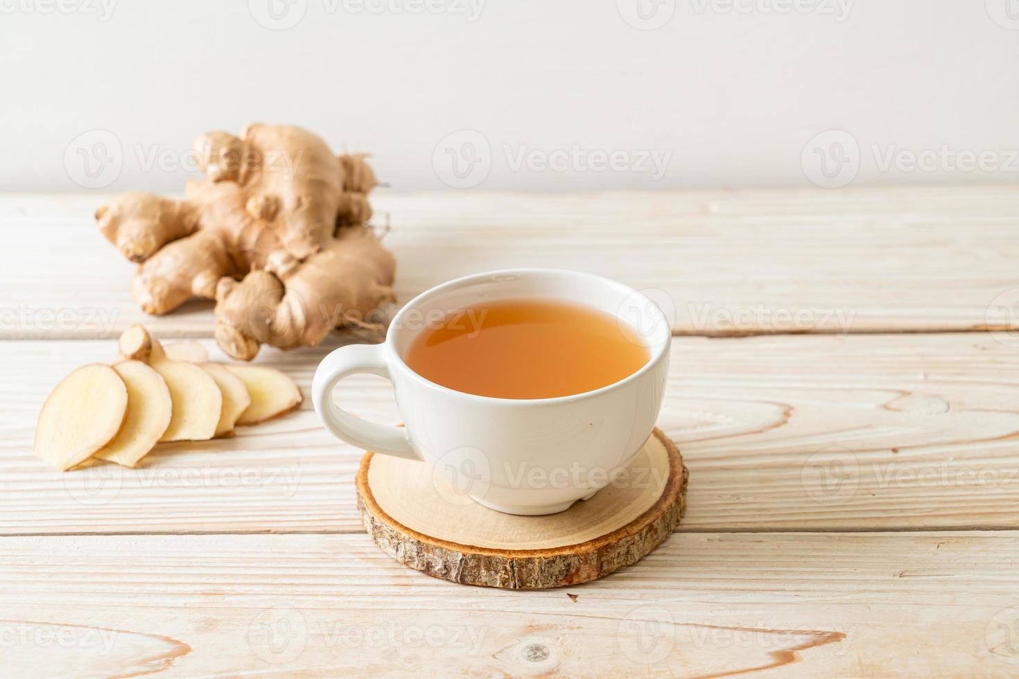 Vaso de jugo de jengibre fresco y caliente con raíces de jengibre - estilo de bebida saludable foto