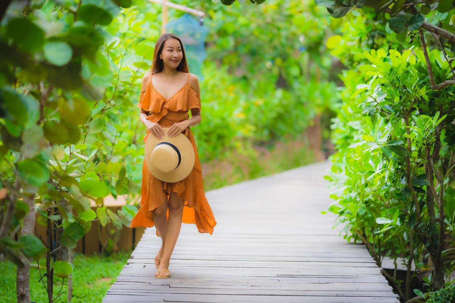 Portrait beautiful young asian woman walk on path walk in the garden photo