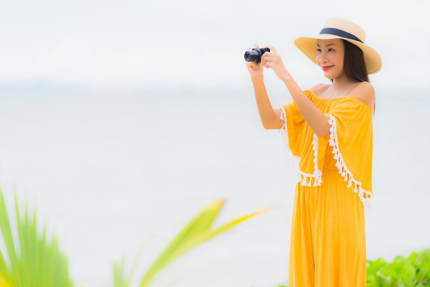 Portrait beautiful asian woman wear hat with smile happy leisure in take a photo on the beach and sea in holiday vacation