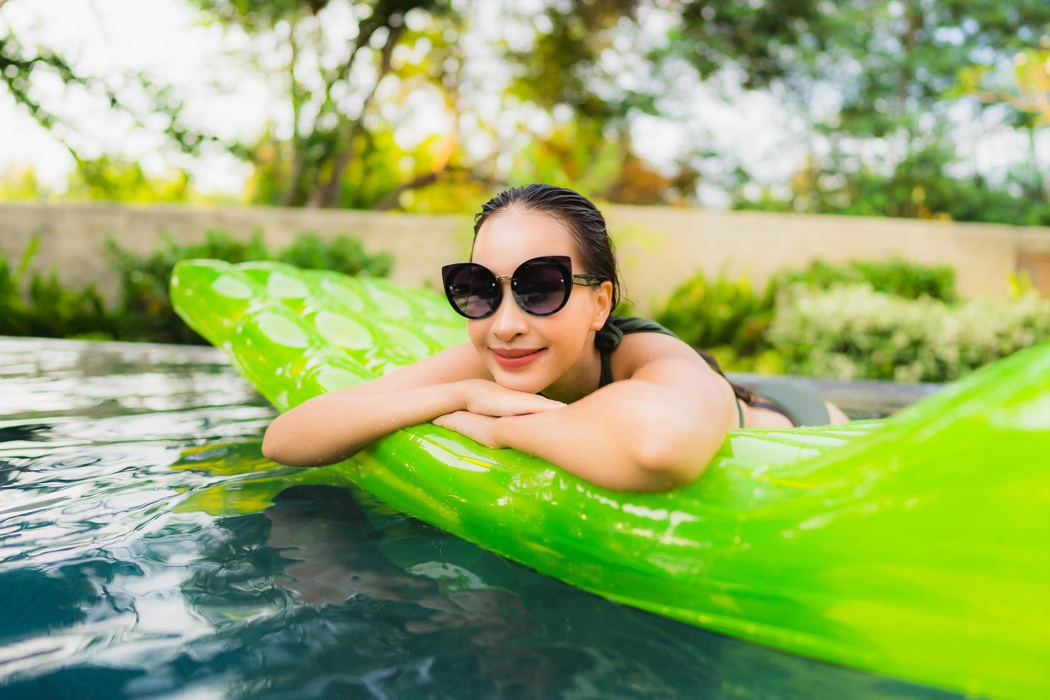 Portrait beautiful young asian woman smile happy relax and leisure in the swimming pool photo