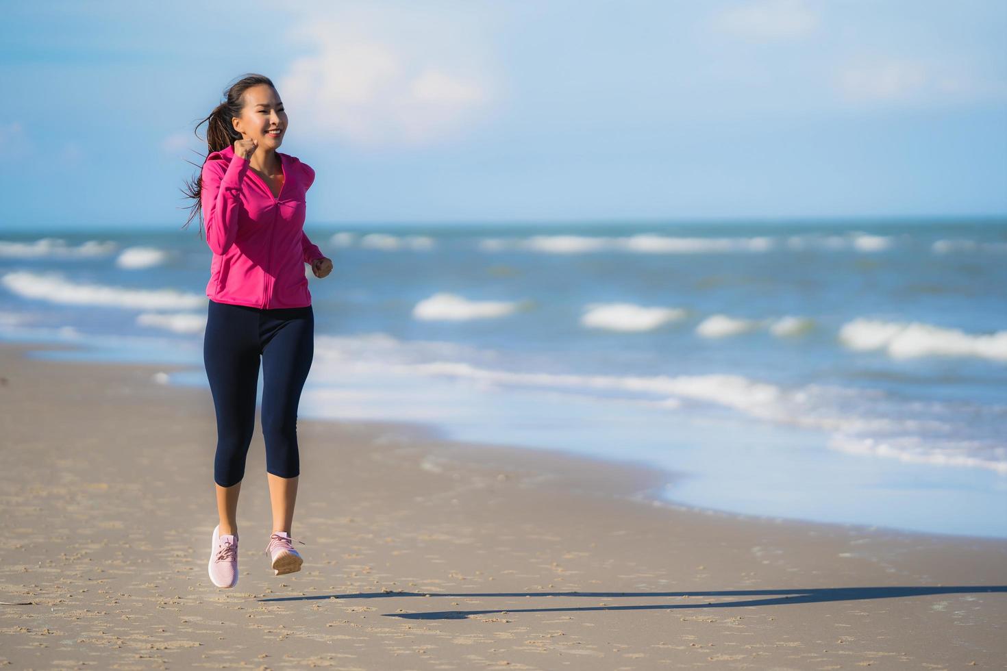 Portrait beautiful young asian woman running and exercising on the tropical outdoor nature beach sea ocean photo