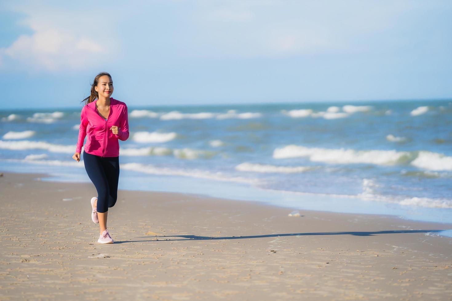 Portrait beautiful young asian woman running and exercising on the tropical outdoor nature beach sea ocean photo