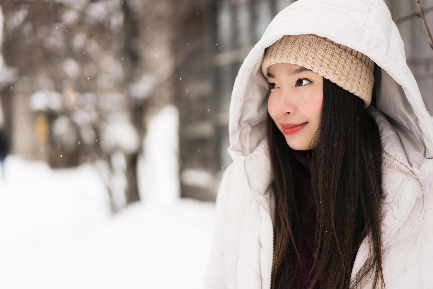 Beautiful young asian woman smiling happy for travel in snow winter season photo