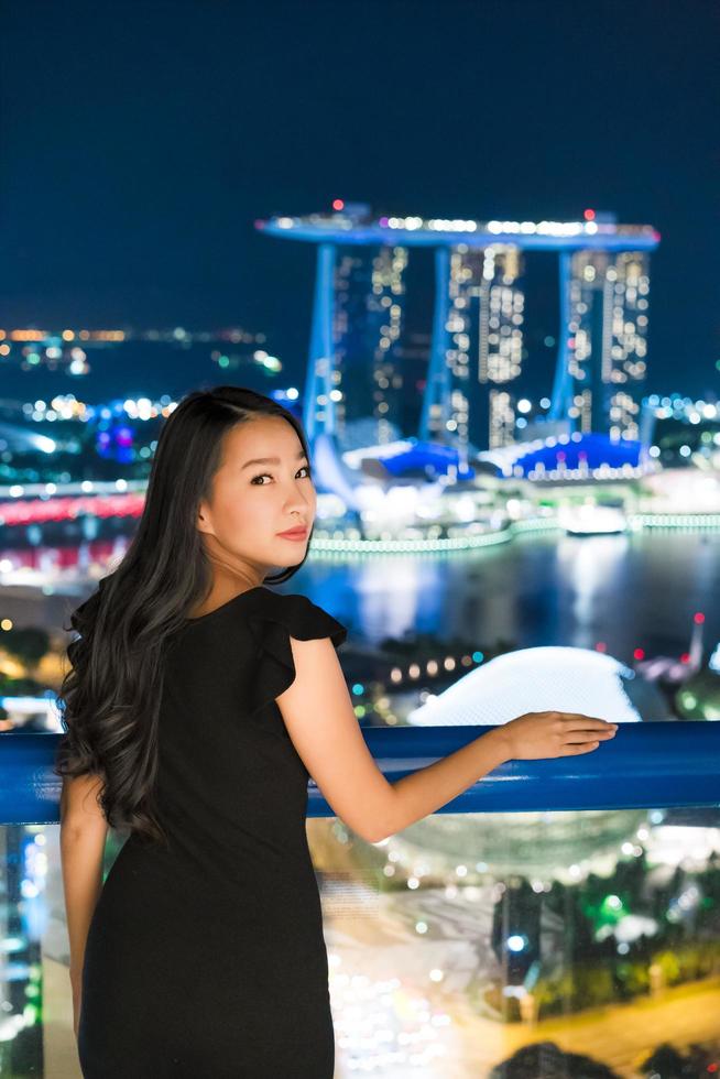 Hermosas mujeres asiáticas sonríen y felices con la vista de la ciudad de Singapur foto