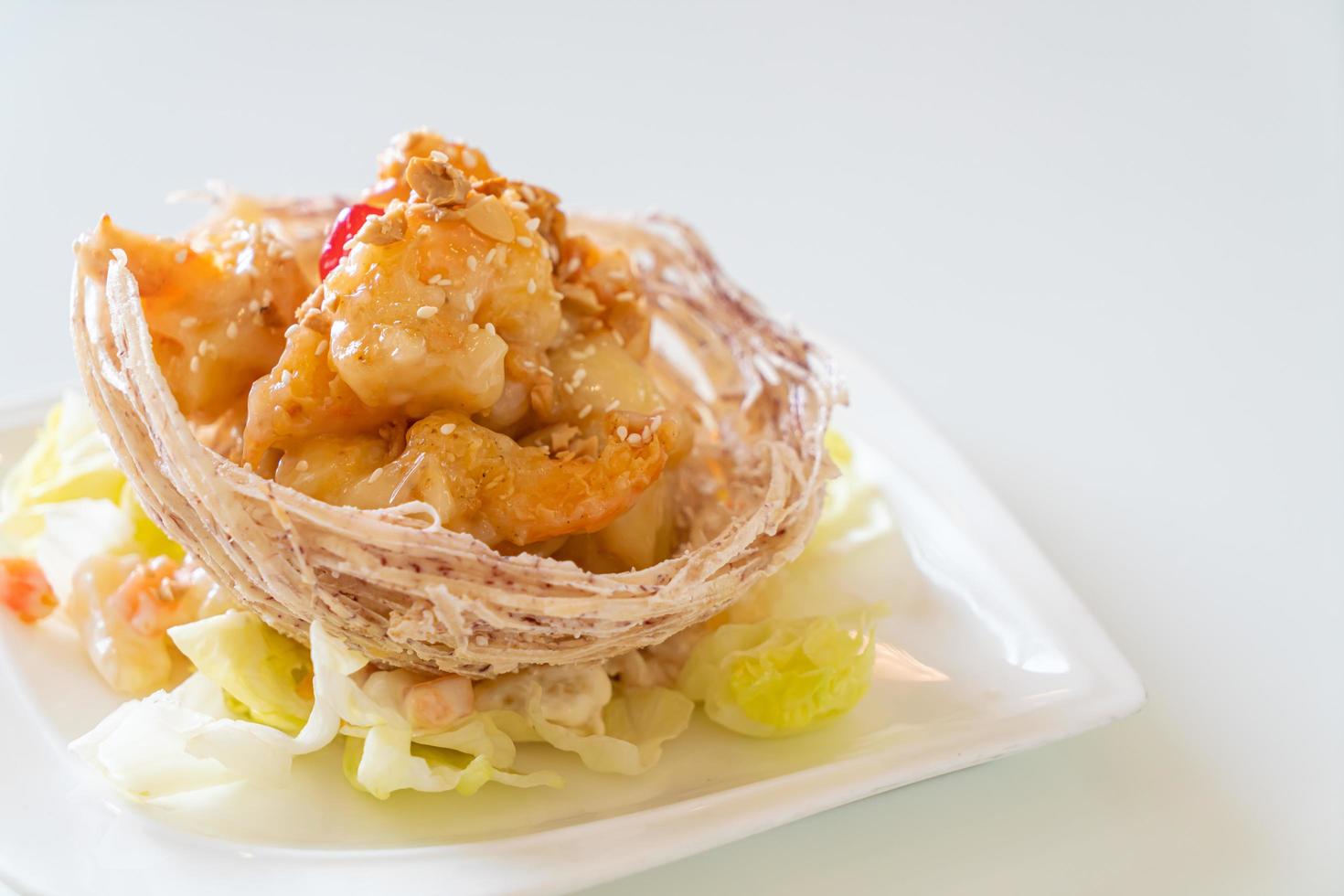 Fried shrimp with salad and fried taro basket topped by salad cream and mayonnaise photo