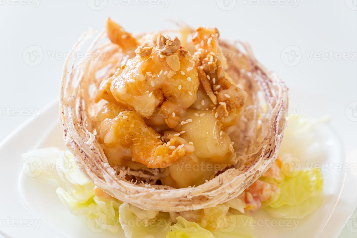 Fried shrimp with salad and fried taro basket topped by salad cream and mayonnaise photo