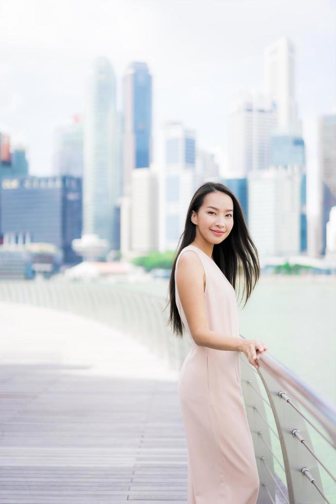 Hermosa mujer asiática sonríe y feliz de viajar a la ciudad de Singapur foto