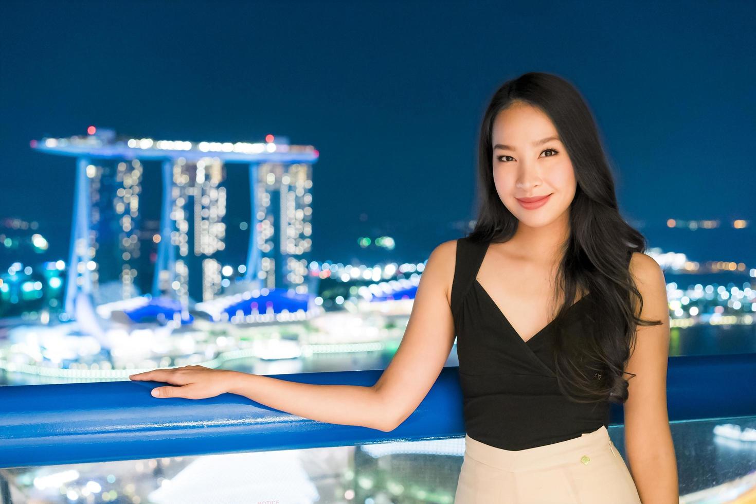 Hermosas mujeres asiáticas sonríen y felices con la vista de la ciudad de Singapur foto