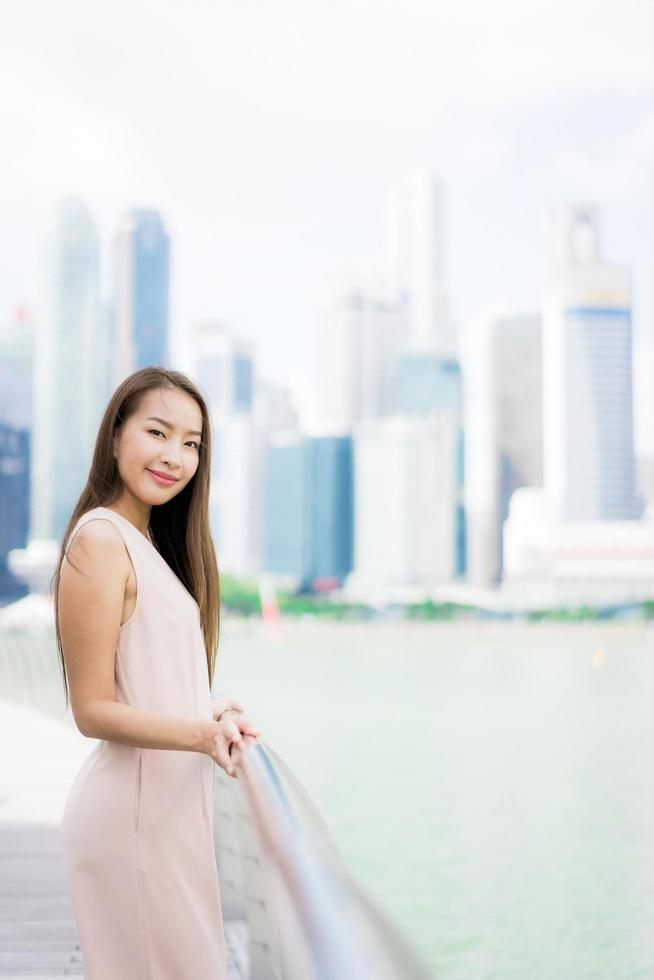 Hermosa mujer asiática sonríe y feliz de viajar a la ciudad de Singapur foto