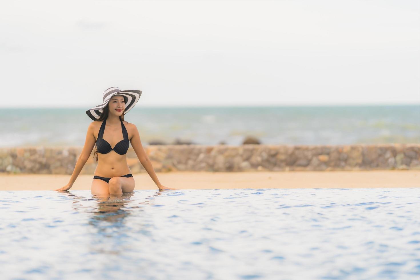 Portrait beautiful young asian woman wear bikini around swimming pool in hotel resort nearly sea ocean beach photo