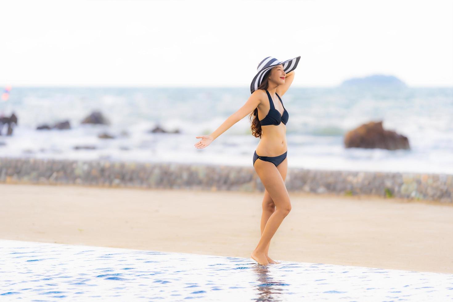Portrait beautiful young asian woman wear bikini around swimming pool in hotel resort nearly sea ocean beach photo
