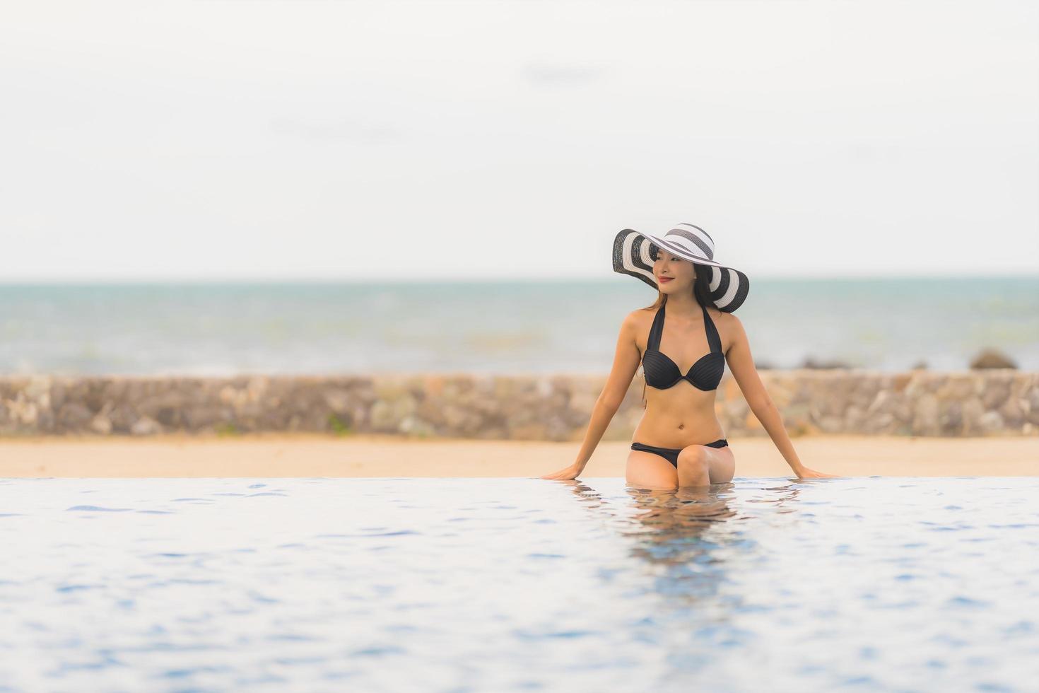 Portrait beautiful young asian woman wear bikini around swimming pool in hotel resort nearly sea ocean beach photo