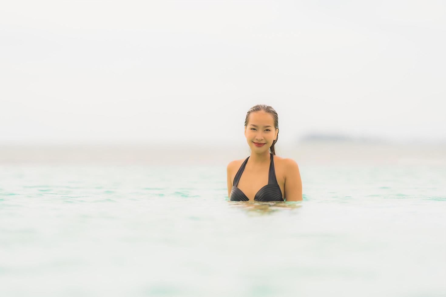 Portrait beautiful young asian woman wear bikini around swimming pool in hotel resort nearly sea ocean beach photo