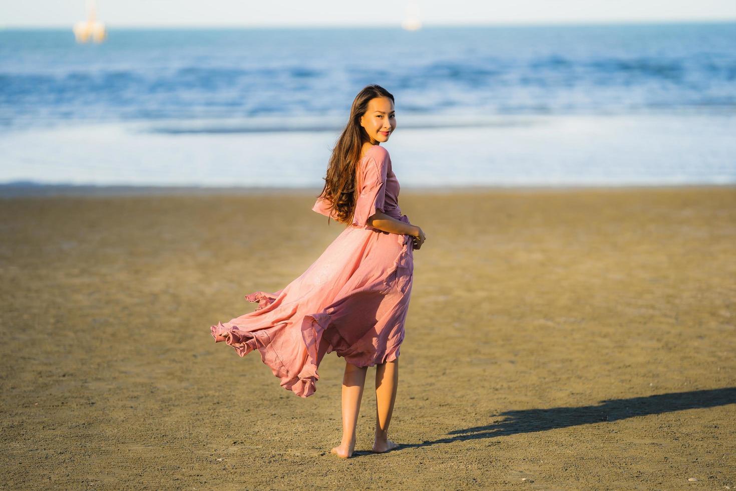 retrato, joven, hermoso, mujer asiática, caminar, sonrisa, y, feliz, en, el, playa, mar y océano foto