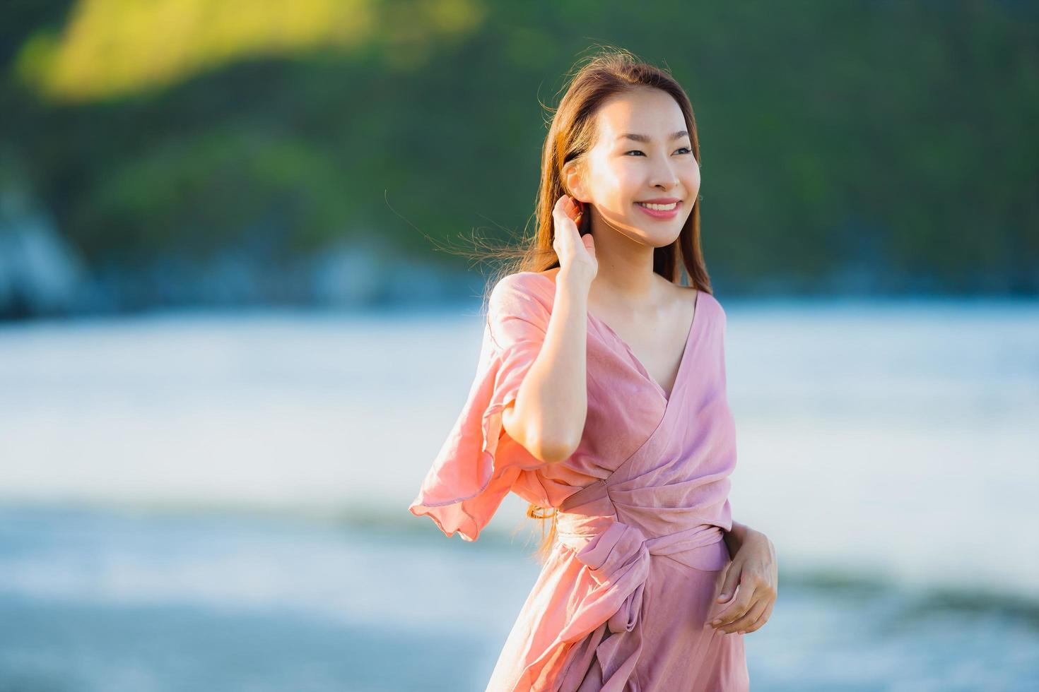 retrato, joven, hermoso, mujer asiática, caminar, sonrisa, y, feliz, en, el, playa, mar y océano foto