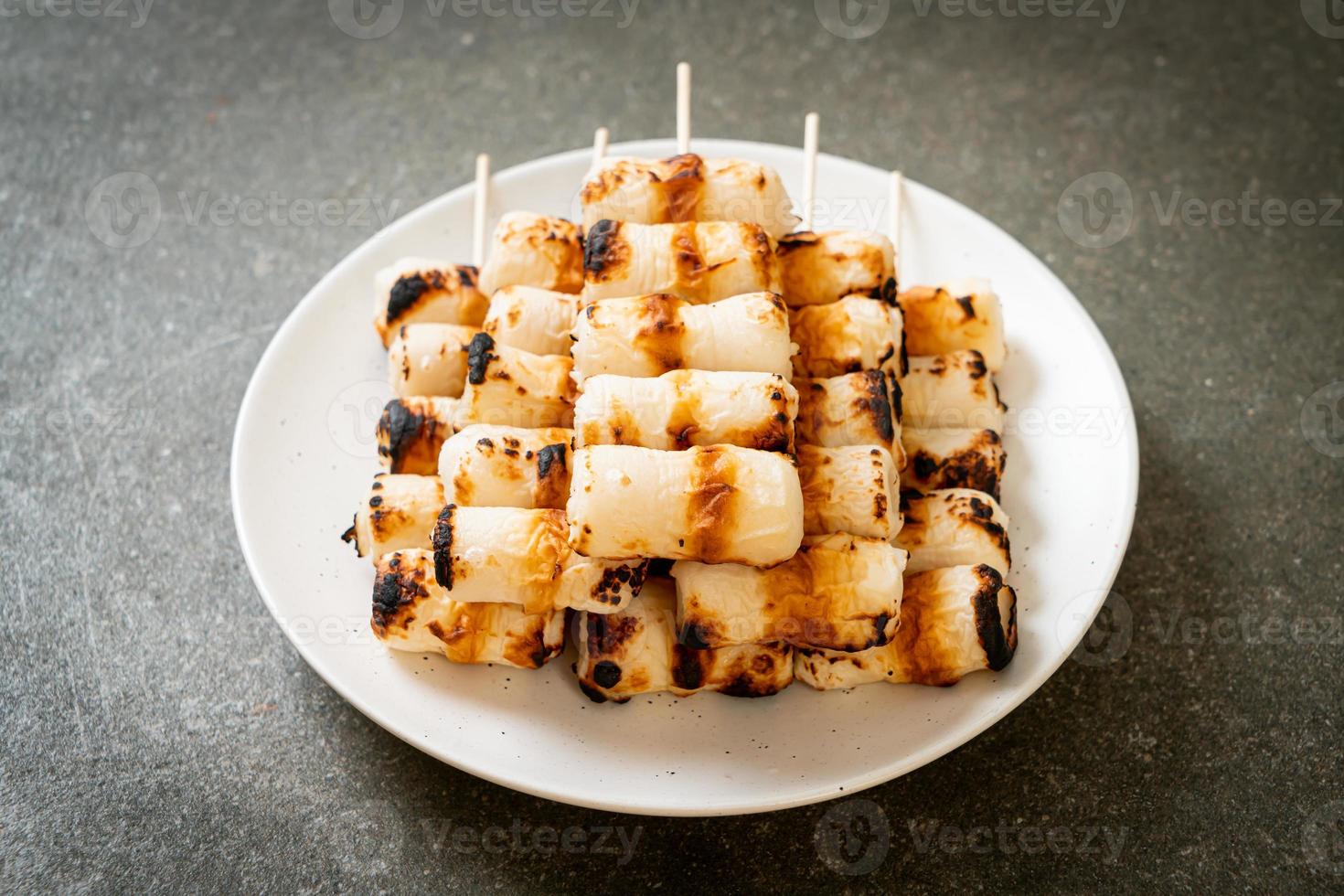 Pastel de pasta de pescado en forma de tubo a la parrilla o pincho de calamar en un plato foto