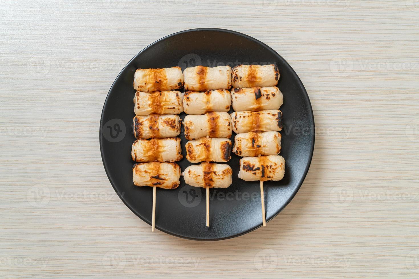 Pastel de pasta de pescado en forma de tubo a la parrilla o pincho de calamar en un plato foto