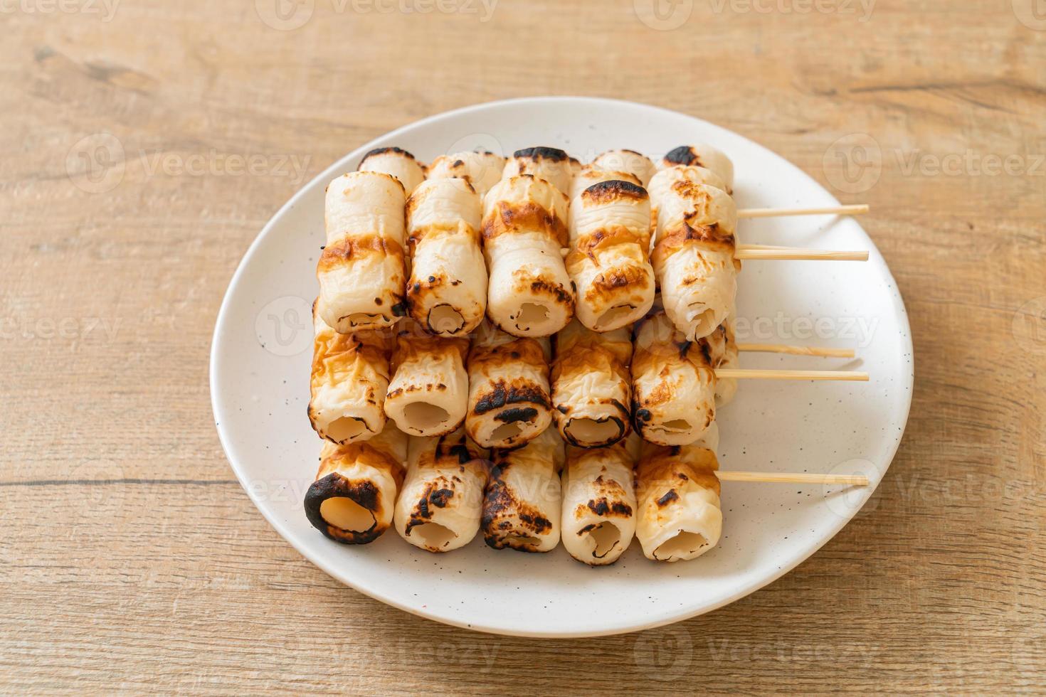 Pastel de pasta de pescado en forma de tubo a la parrilla o pincho de calamar en un plato foto