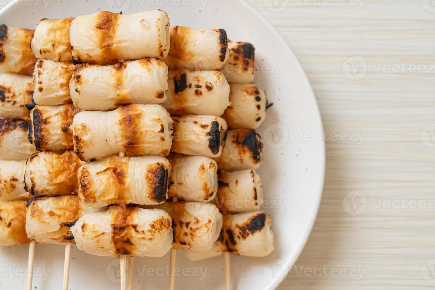 Pastel de pasta de pescado en forma de tubo a la parrilla o pincho de calamar en un plato foto