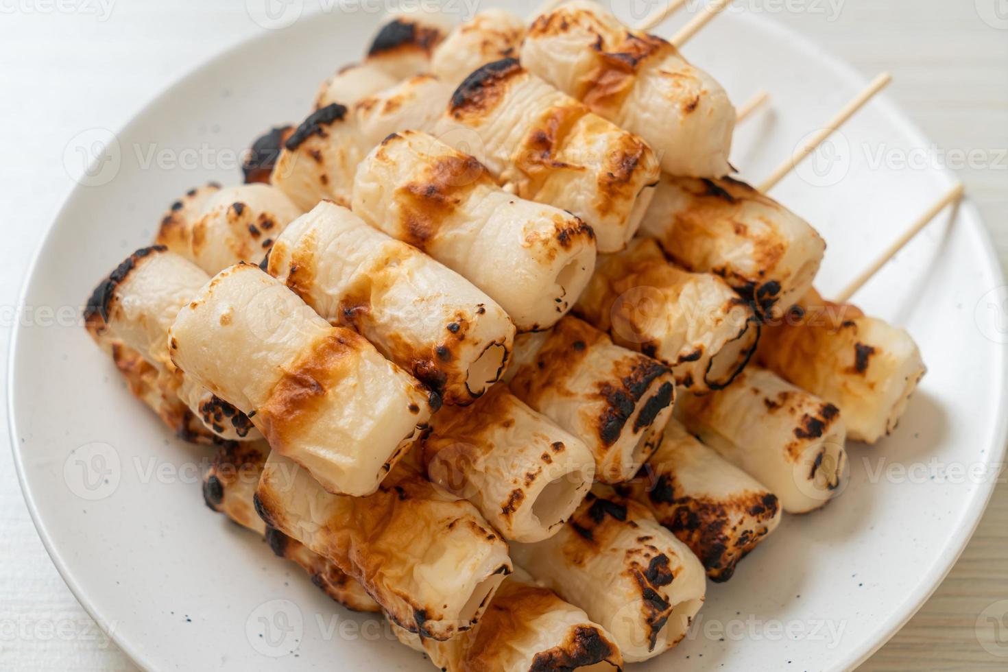 Grilled tube-shaped fish paste cake or tube squid skewer on plate photo