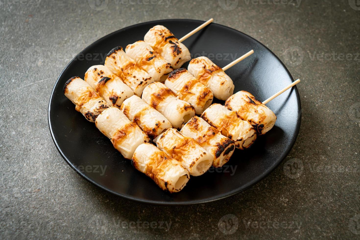 Grilled tube-shaped fish paste cake or tube squid skewer on plate photo