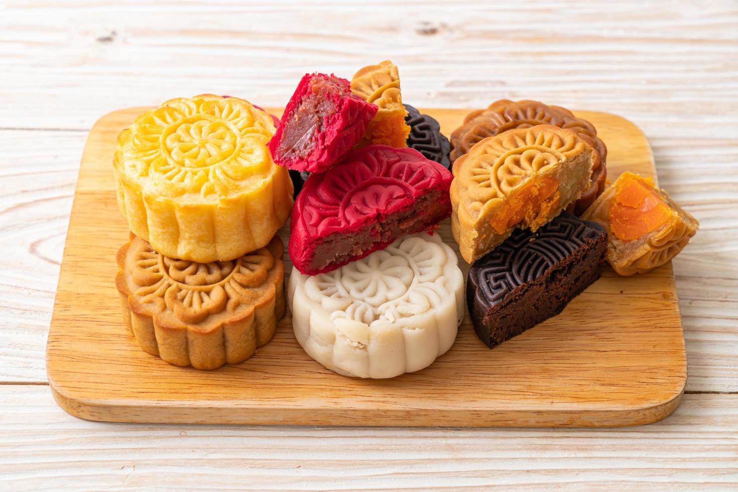 Colorful Chinese moon cake with mixed flavor on wood plate photo