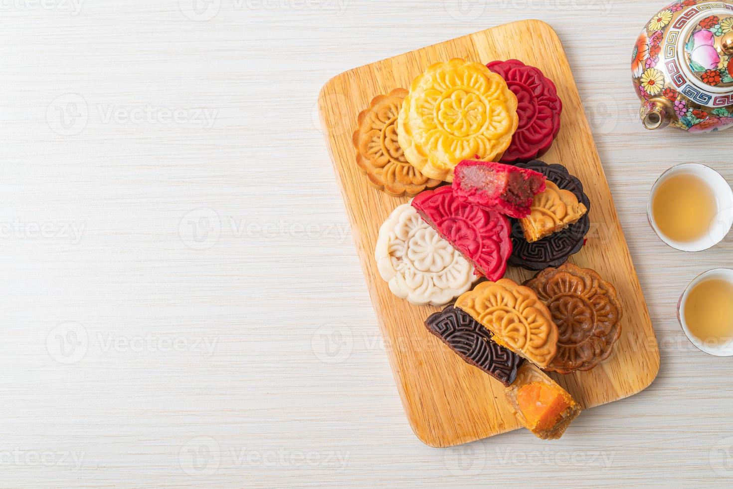 Colorful Chinese moon cake with mixed flavor on wood plate photo