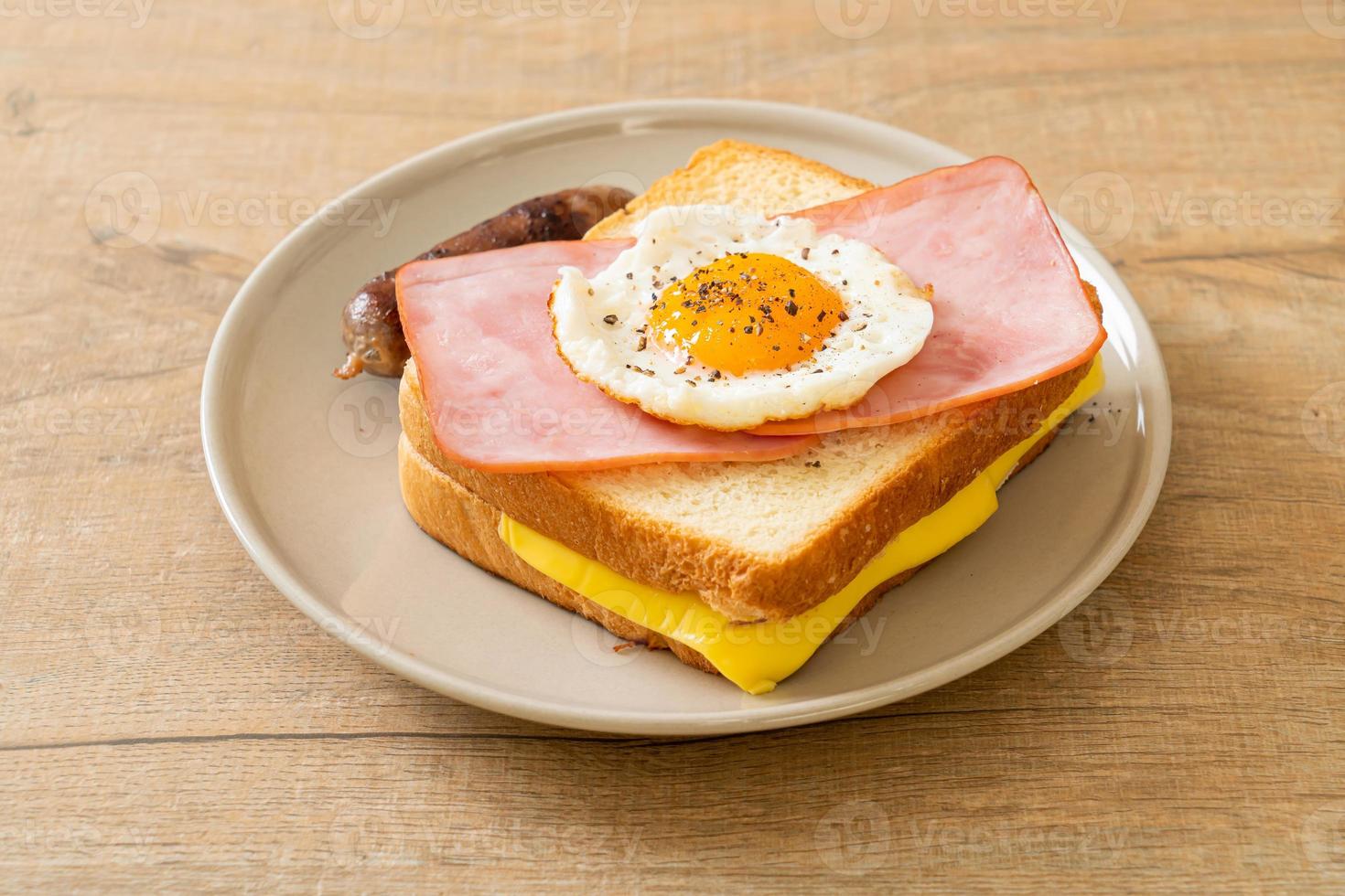 Pan casero con jamón tostado con queso y huevo frito con salchicha de cerdo para el desayuno foto