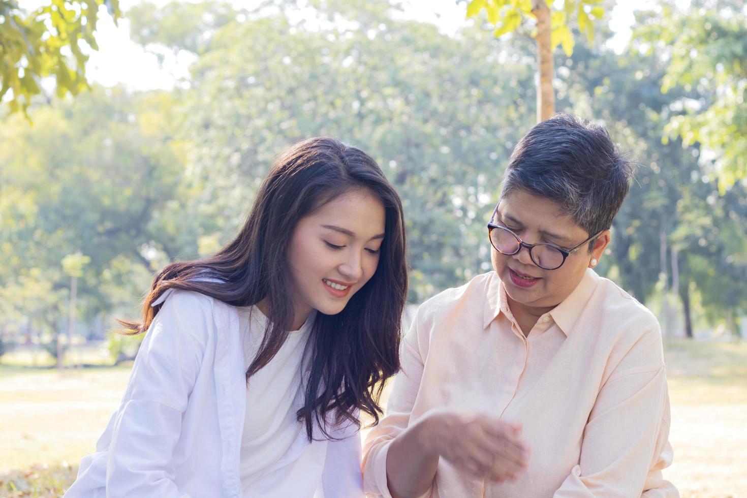 Asian mother and daughter sitting Relax in the park photo