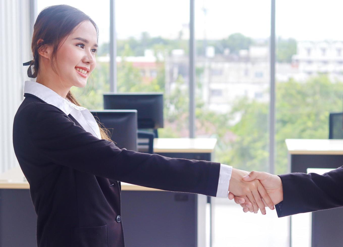 Asian businesswoman smiles and shaking hands after signing a business contract photo
