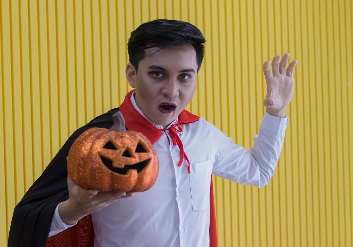 Hombre sujetando calabazas naranjas en la noche de halloween foto