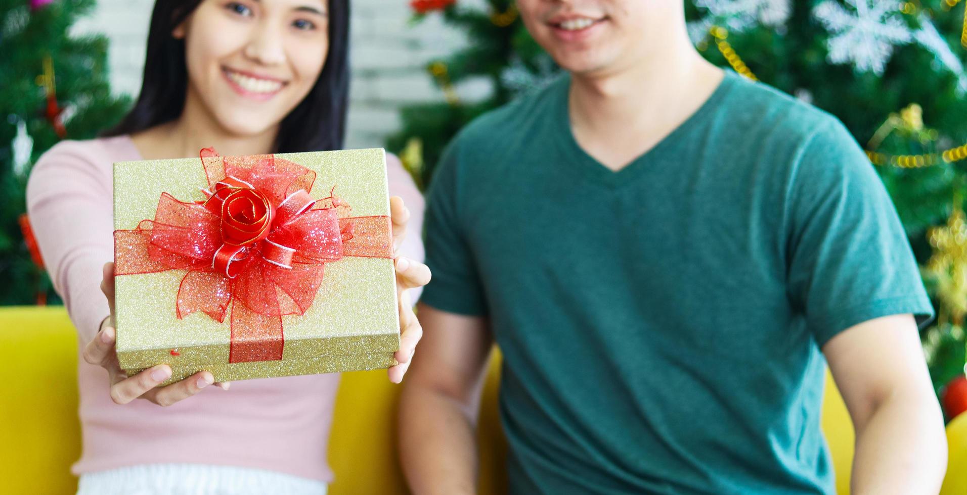 joven pareja asiática está dando un regalo de Navidad. el concepto de una vida feliz en navidad foto