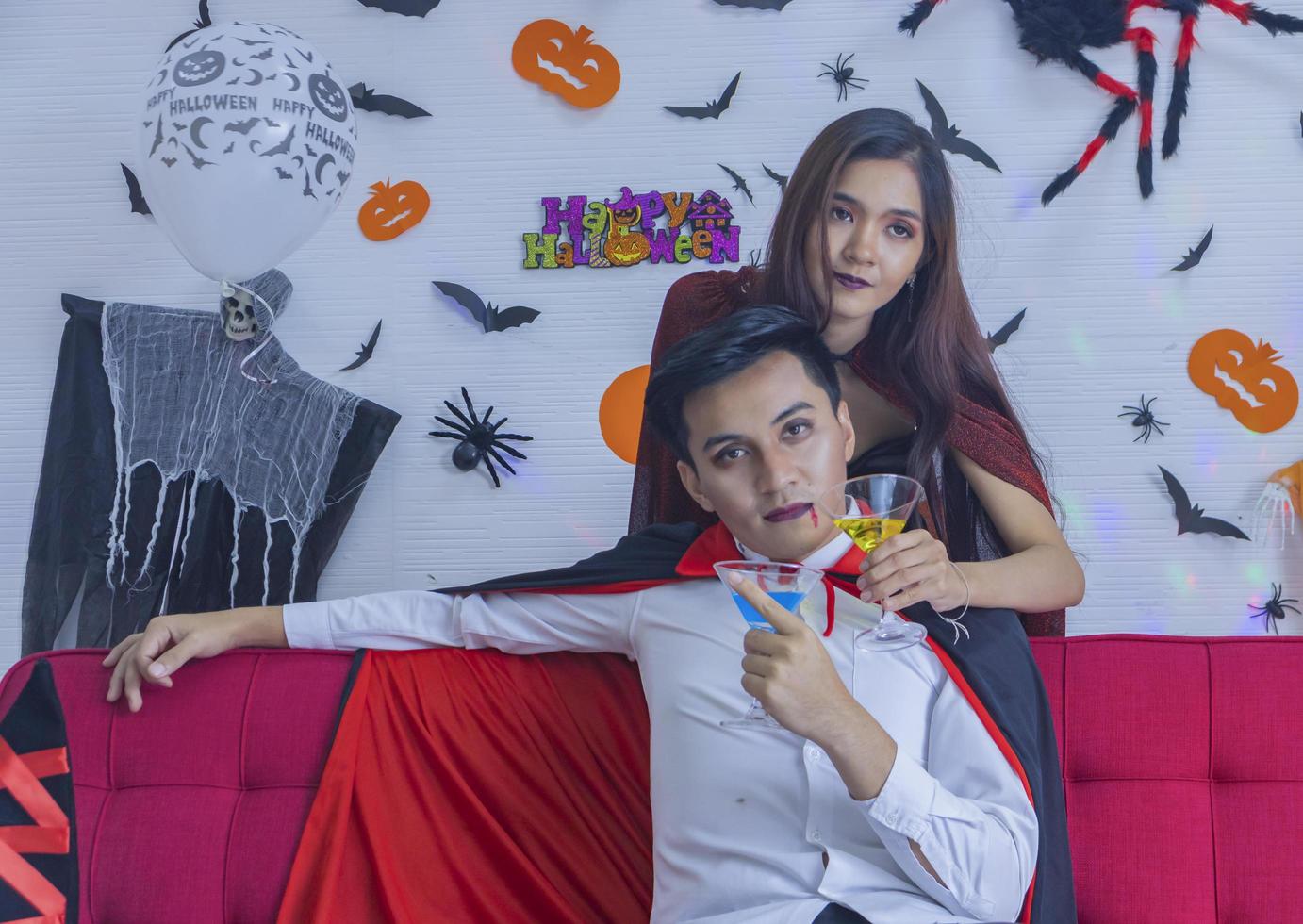 pareja joven divirtiéndose bebiendo y celebrando la fiesta de halloween foto