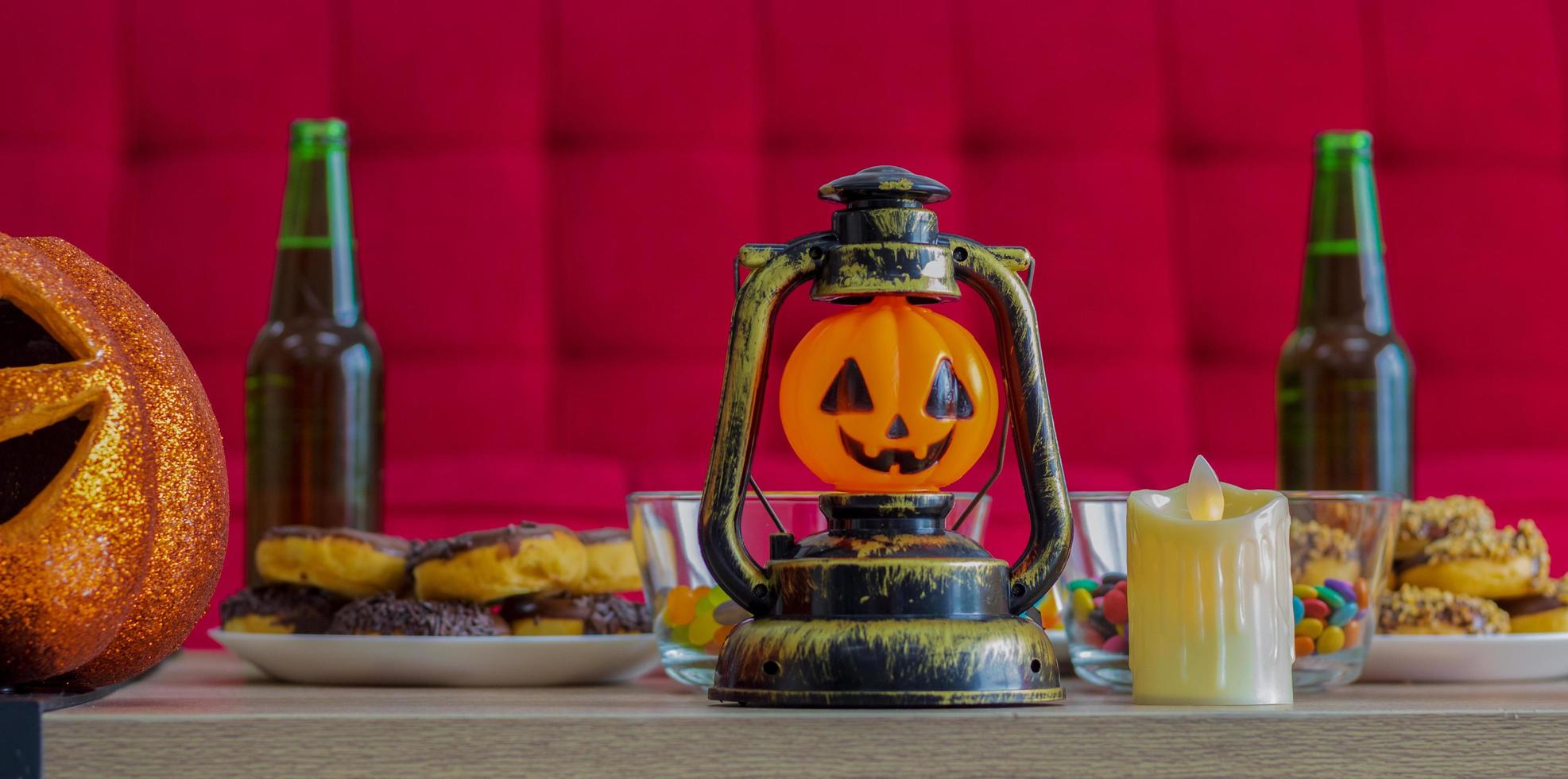 Calabaza naranja en la noche de Halloween con velas y dulces beben en celebración de Halloween foto