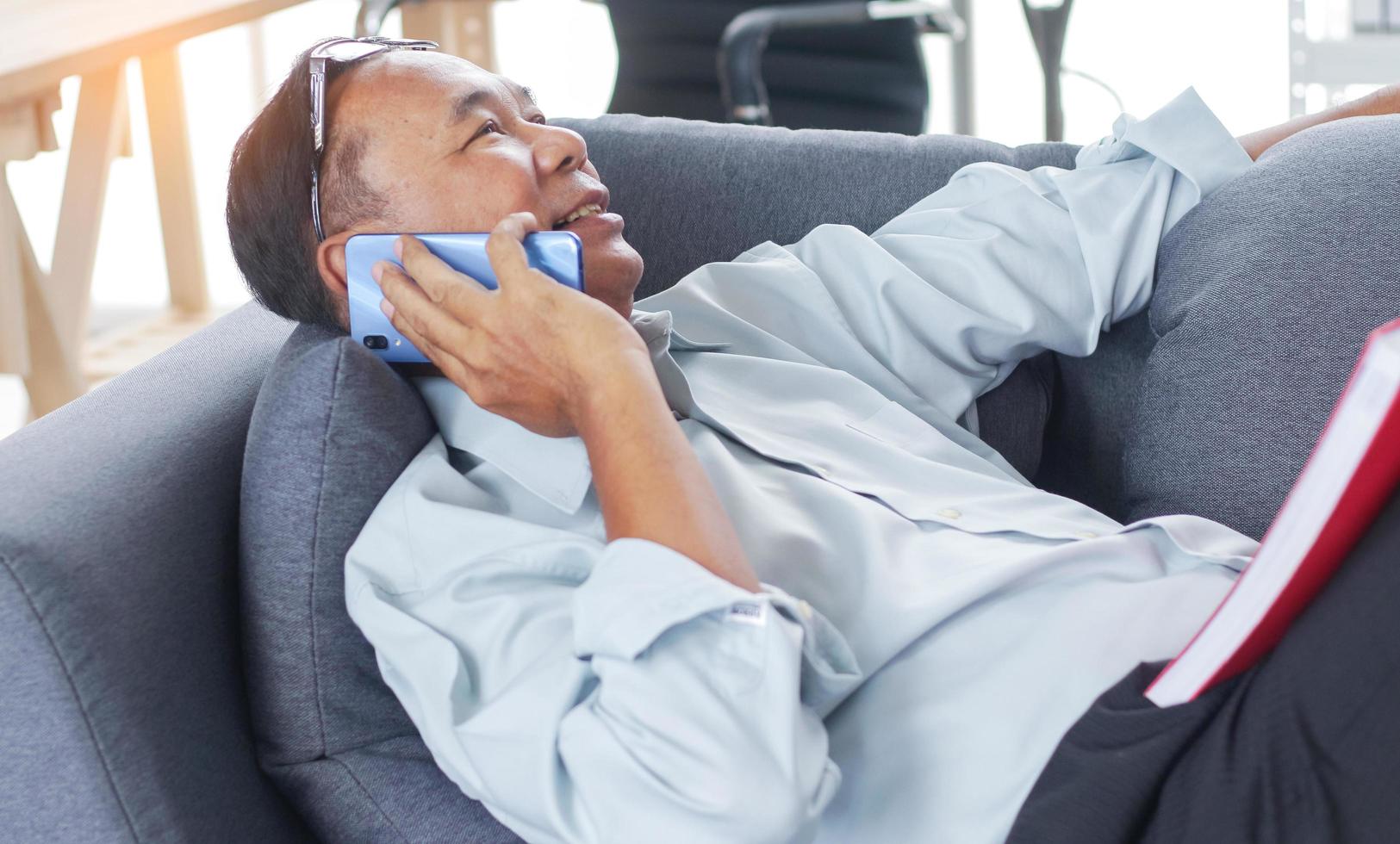 Man talking on the phone Happily on sofa photo