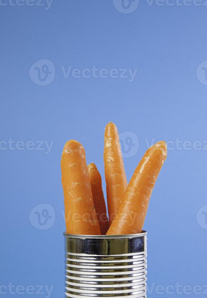 Canned carrots with blue background photo