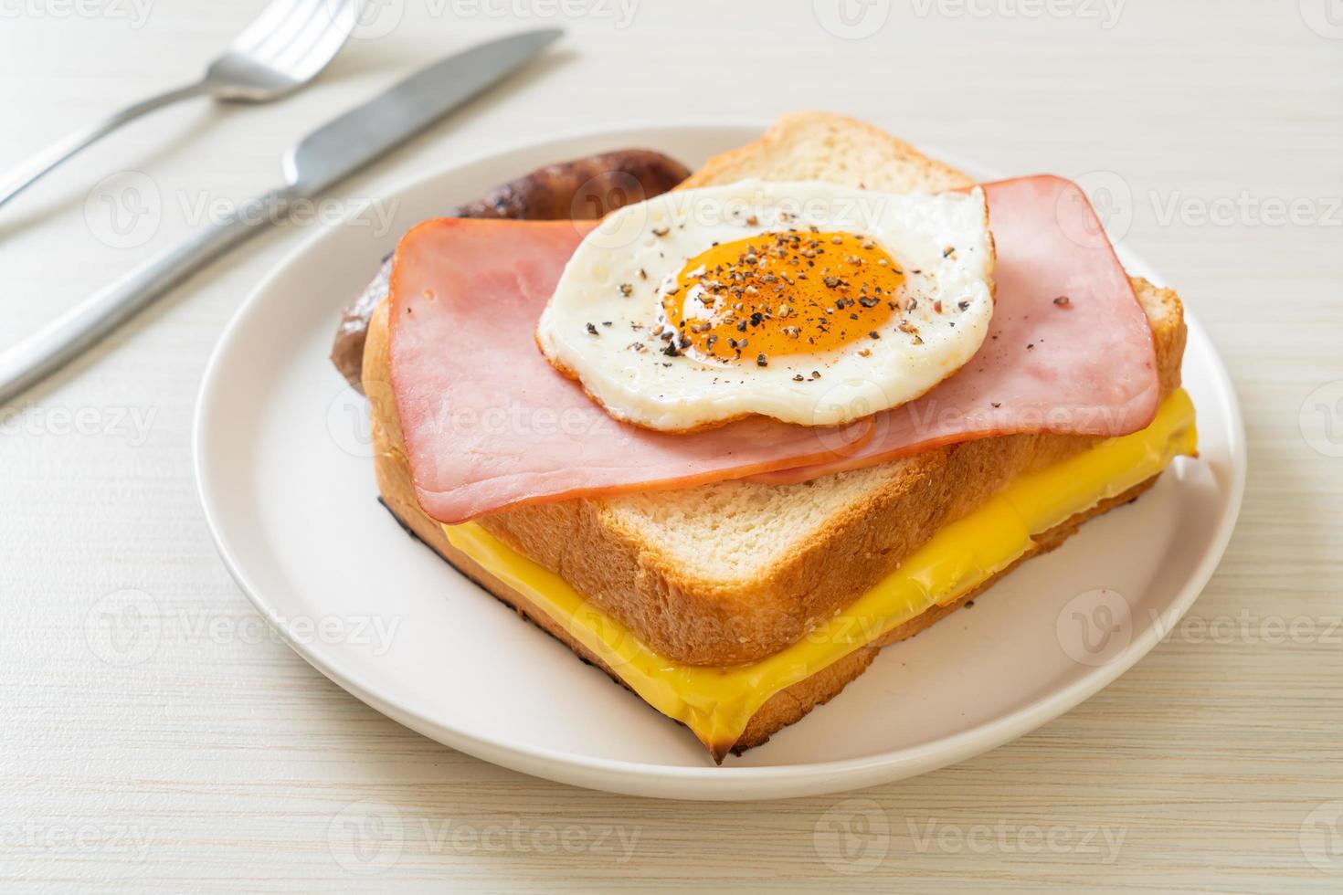 pan casero, queso tostado, jamón cubierto y huevo frito con salchicha de cerdo para el desayuno foto