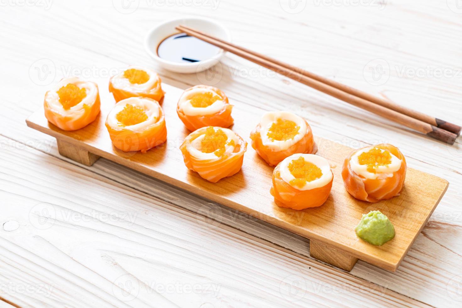 Rollo de sushi de salmón fresco con mayonesa y huevo de camarón - estilo de comida japonesa foto