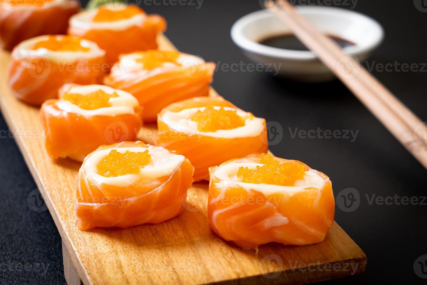 Rollo de sushi de salmón fresco con mayonesa y huevo de camarón - estilo de comida japonesa foto