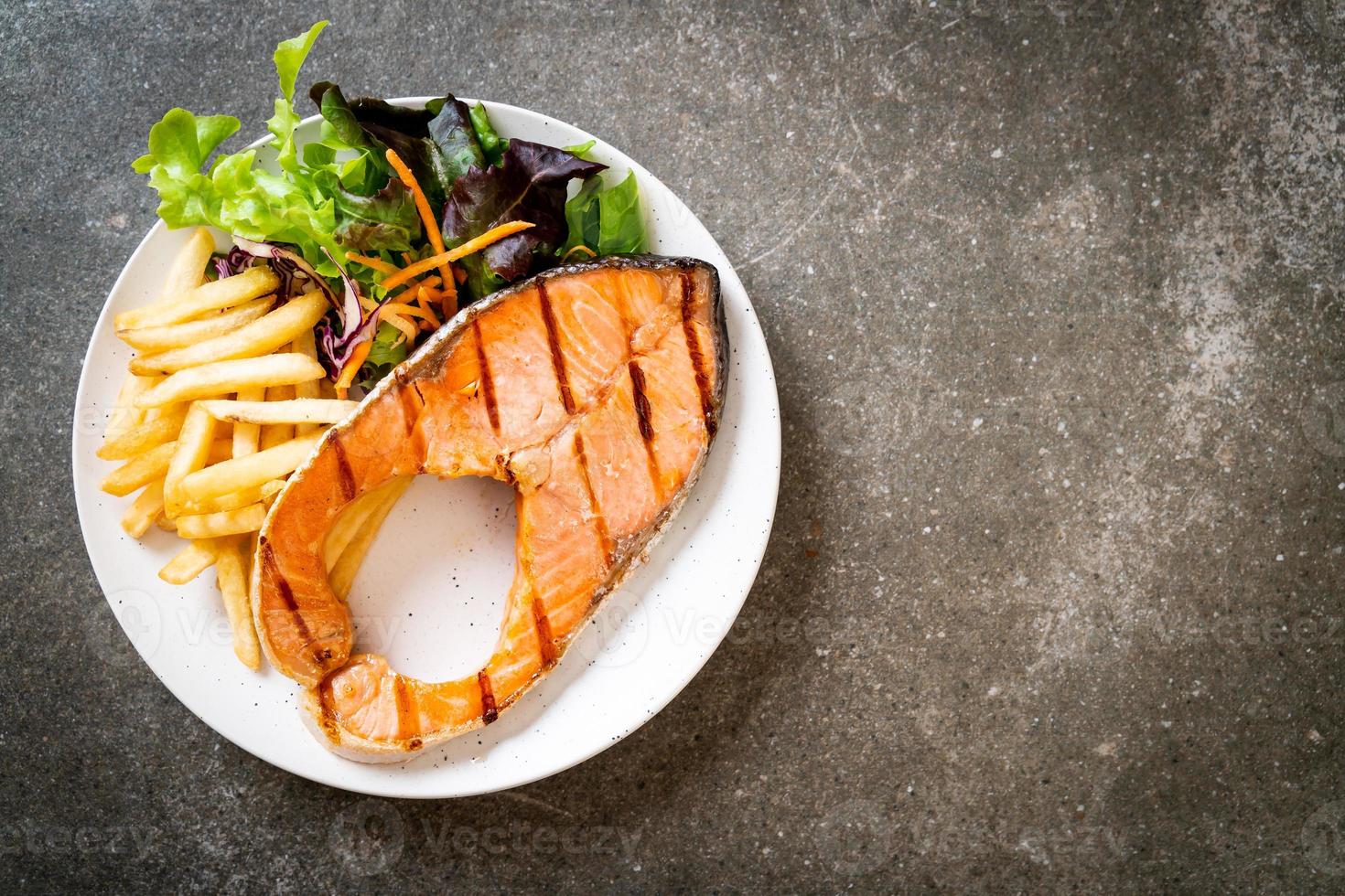 Double grilled salmon steak fillet with vegetable and french fries photo