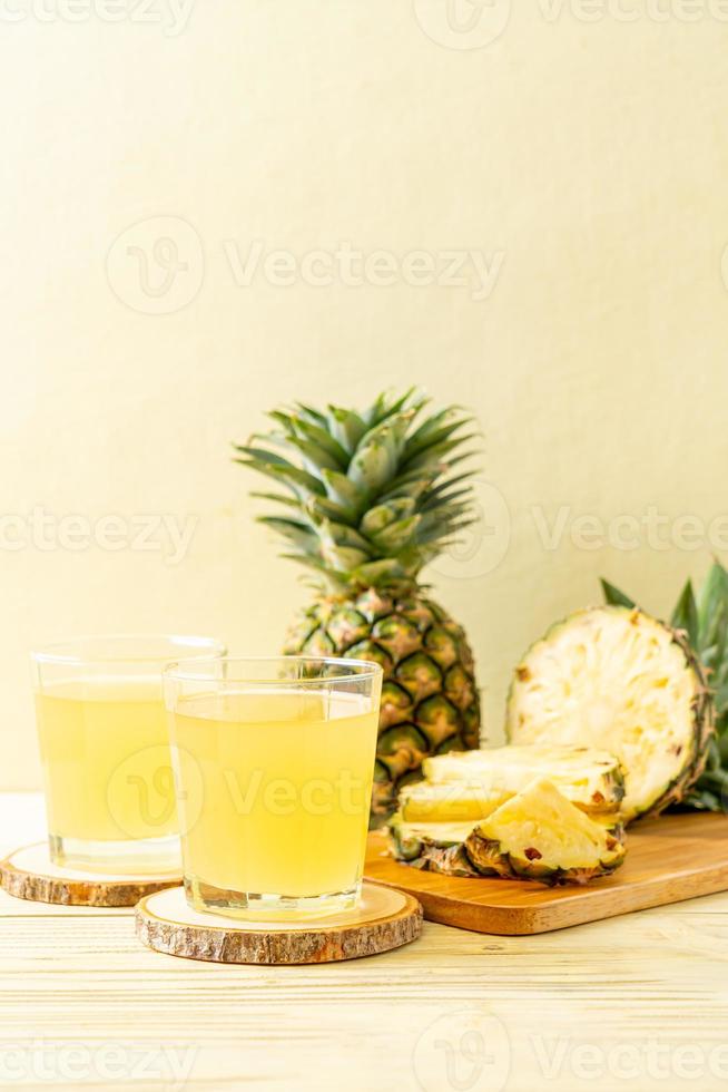 Fresh pineapple juice on wood background photo