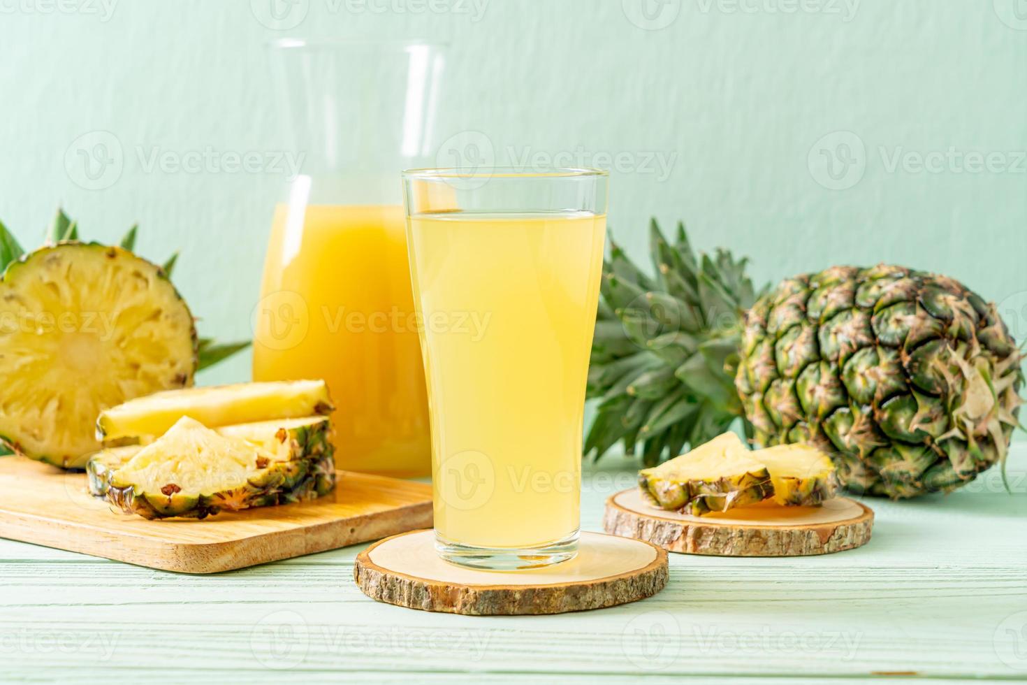 Jugo de piña fresca sobre fondo de madera foto