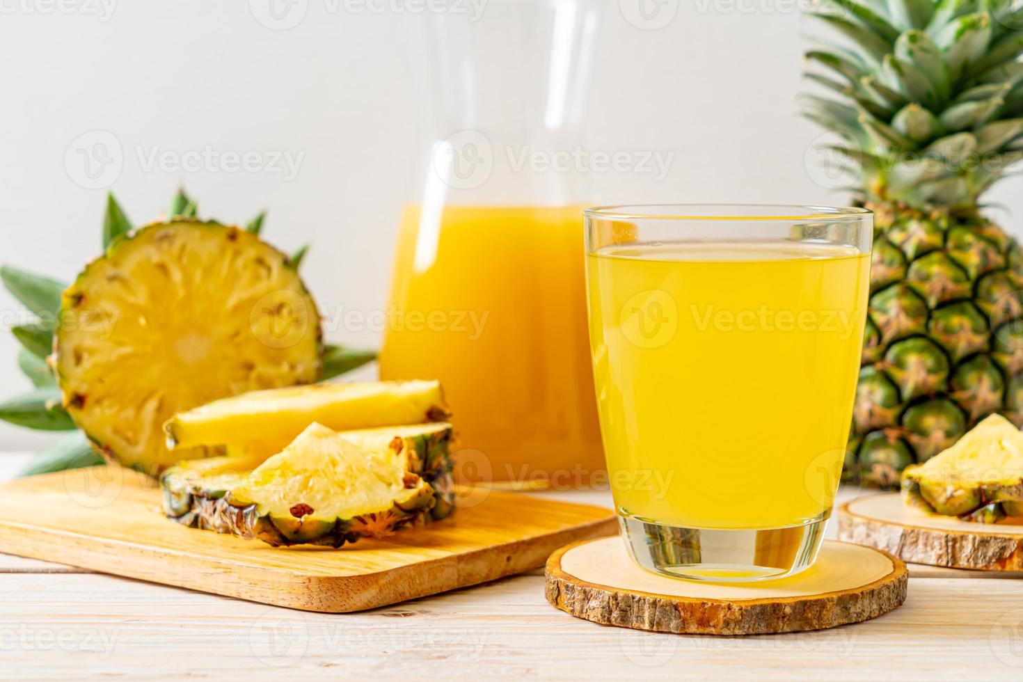 Jugo de piña fresca sobre fondo de madera foto