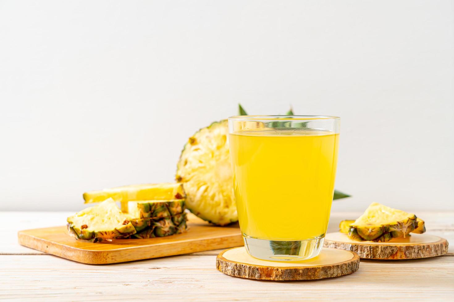 Fresh pineapple juice on wood background photo